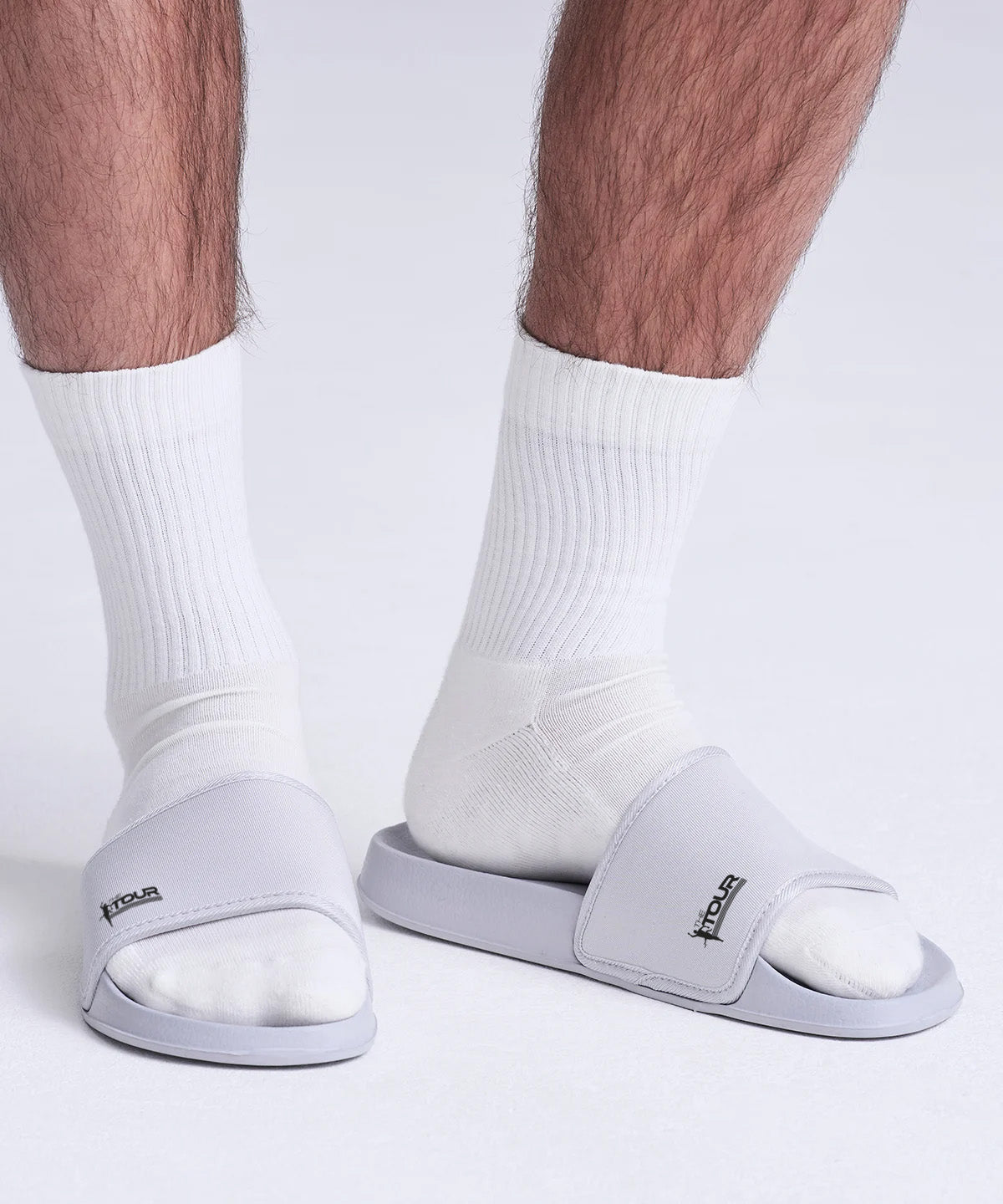 Gray slides worn with white socks on a plain background